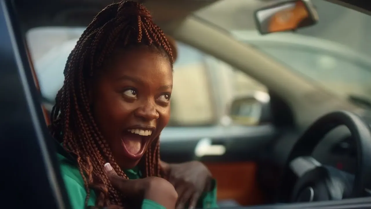 Woman with dreadlocks in driver's seat of car